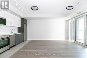 Toronto (University) condo for rent - A spacious kitchen with white cabinets and a large window.
