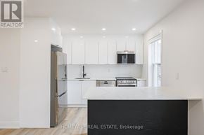Toronto (Casa Loma) apartment for rent - A modern kitchen with white cabinets and a black counter.