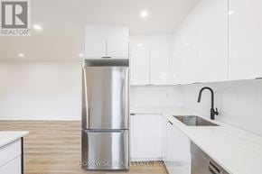 Toronto (Casa Loma) apartment for rent - A modern kitchen with white cabinets and a stainless steel refrigerator.