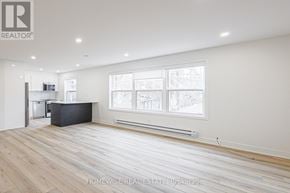 Toronto (Casa Loma) apartment for rent - A spacious room with wooden flooring and a large window.