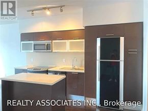 Toronto (Bay Street Corridor) condo for rent - A modern kitchen with a sink, microwave, and refrigerator.