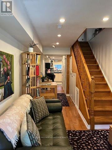 Toronto (Greenwood-Coxwell) apartment for rent - A living room with a couch and a staircase.