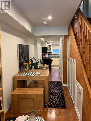 Toronto (Greenwood-Coxwell) apartment for rent - A hallway with a wooden floor and a staircase on the right side.