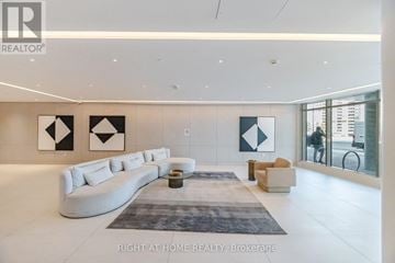 Vaughan (Brownridge) condo for rent - A spacious living room with a white sofa and a grey rug.