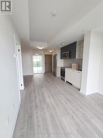 Toronto (Junction Area) condo for rent - A spacious kitchen with white cabinets and a microwave above the oven.