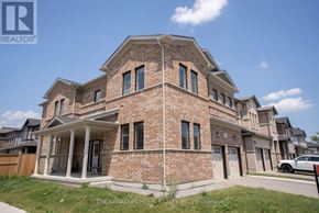 Kitchener apartment for rent - A large brick house with a porch and a garage.