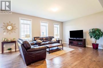 Kitchener apartment for rent - A living room with a leather couch and a flat screen TV.