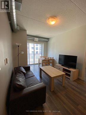 Waterloo condo for rent - A living room with a brown leather couch and a wooden coffee table.