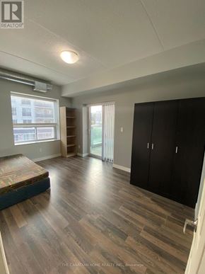 Waterloo condo for rent - A room with wooden flooring and a large window.