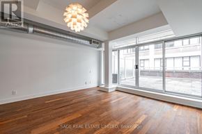 Toronto (South Riverdale) condo for rent - A room with wooden floors and a large window overlooking a city street.