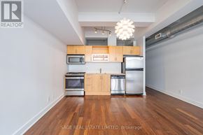 Toronto (South Riverdale) condo for rent - A kitchen with wooden floors and stainless steel appliances.