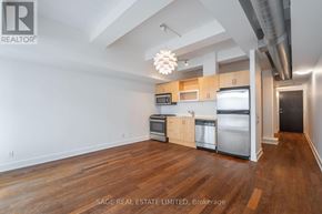 Toronto (South Riverdale) condo for rent - A kitchen with wooden floors and stainless steel appliances.