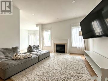 Vaughan (Patterson) apartment for rent - A living room with a grey couch and a fireplace.