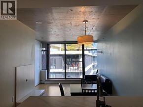 Vancouver apartment for rent - A room with a table and chairs in front of a large window.
