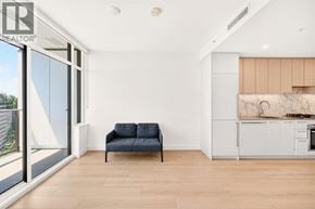 Burnaby apartment for rent - A living room with a blue couch and a kitchen area in the background.