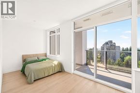 Burnaby apartment for rent - A bedroom with a bed, a window, and a sliding glass door leading to a balcony.