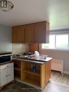 Ottawa triplex for rent - A kitchen with wooden cabinets and a tile floor.