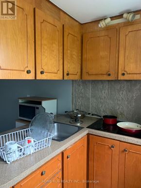 Ottawa triplex for rent - A kitchen with wooden cabinets and a sink.