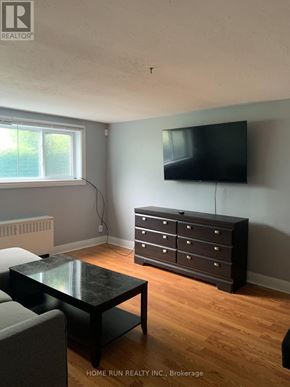 Ottawa triplex for rent - A black coffee table sits in front of a grey couch in a living room.