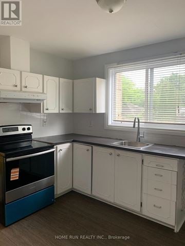 Ottawa triplex for rent - A kitchen with white cabinets and a blue oven.