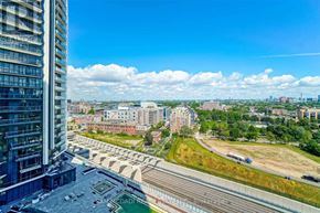 Toronto (Niagara) condo for rent - A view from a high-rise building looking out over a cityscape with a bridge and railway tracks.
