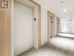 Toronto (Niagara) condo for rent - A hallway with doors on both sides and a REALTOR sign on the wall.