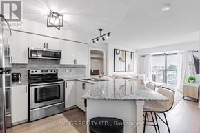 Toronto (Bathurst Manor) condo for rent - A modern kitchen with a granite countertop and stainless steel appliances.