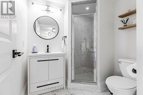 Toronto (Bathurst Manor) condo for rent - A white bathroom with a toilet, sink, and mirror.
