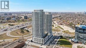 Toronto (Agincourt South-Malvern West) condo for rent - A tall building with a glass facade stands in the foreground of a cityscape.