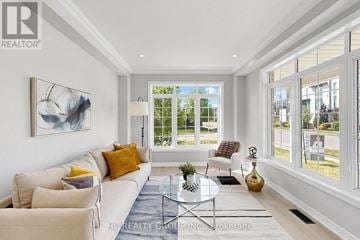 Vaughan (Patterson) apartment for rent - A well-lit living room with a white sofa, a glass coffee table, and a large painting on the wall.