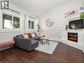 Hamilton apartment for rent - A living room with a grey couch, a fireplace, and a television.