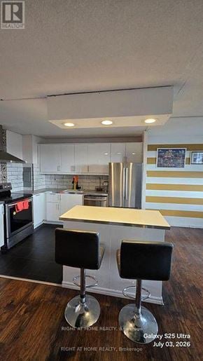 Toronto (Flemingdon Park) condo for rent - A kitchen with a bar stool in front of it.