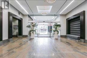 Toronto (Waterfront Communities) condo for rent - A hallway with a wooden floor and a chandelier hanging from the ceiling.