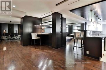 Toronto (Waterfront Communities) condo for rent - A modern kitchen with dark wood floors and black cabinets.
