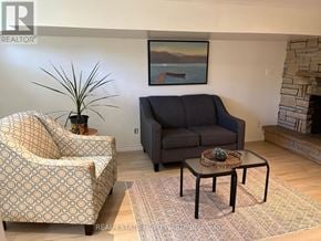 Toronto (Woburn) apartment for rent - A living room with a grey couch, a patterned armchair, and a coffee table.