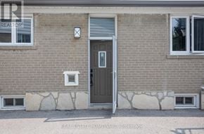 Toronto (Woburn) apartment for rent - A brick house with a grey door and windows.