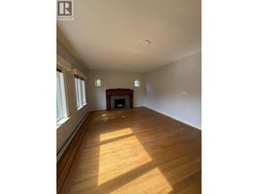 Vancouver apartment for rent - A large empty room with wooden floors and a fireplace.