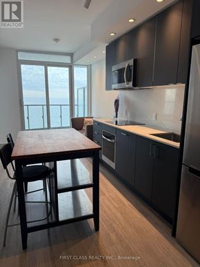 Toronto (South Parkdale) condo for rent - A kitchen with a wooden table and black chairs.