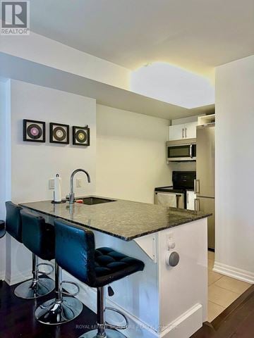 Ottawa condo for rent - A kitchen with a black counter top and white cabinets.