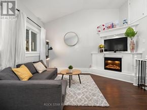 Hamilton (North End) apartment for rent - A living room with a grey couch, a fireplace, and a coffee table.
