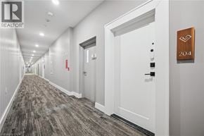 Guelph condo for rent - A hallway with a door numbered 204 and a sign that says REALTOR.