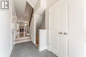 Ottawa townhouse for rent - A hallway with a staircase and white doors.