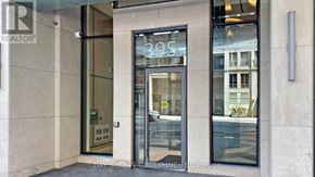 Toronto (North St. James Town) condo for rent - The entrance to a building with a glass door and a sign that reads "REALTOR".