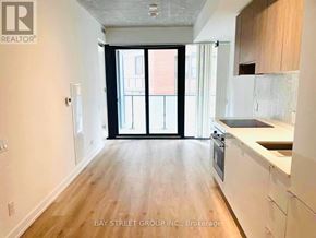 Toronto (Mount Pleasant West) condo for rent - A spacious kitchen with white cabinets and a wooden floor.