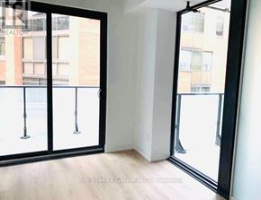 Toronto (Mount Pleasant West) condo for rent - A room with a view of a street through a glass door.