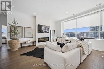 Guelph (Pineridge/Westminster Woods) condo for rent - A modern living room with a white sofa and a black rug.