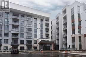 Milton (Walker) condo for rent - A large white building with multiple balconies and a car parked in front.