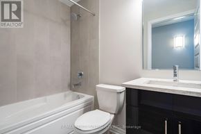 Milton (Walker) condo for rent - A white toilet sits next to a bathtub in a bathroom.
