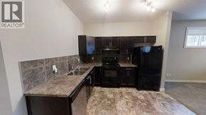 Grande Prairie apartment for rent - A kitchen with black appliances and a marble countertop.