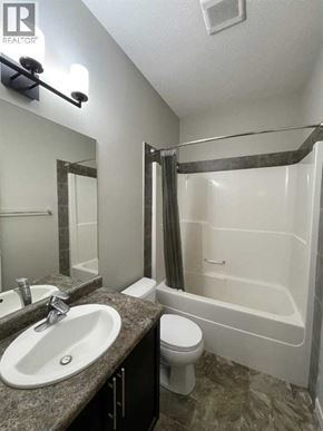 Grande Prairie apartment for rent - A bathroom with a sink, toilet, and bathtub.